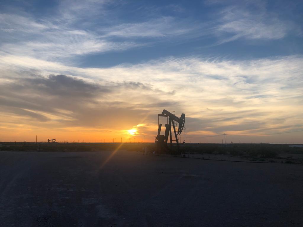 Producing pumping unit on a Sunergon oilfield location at sunset